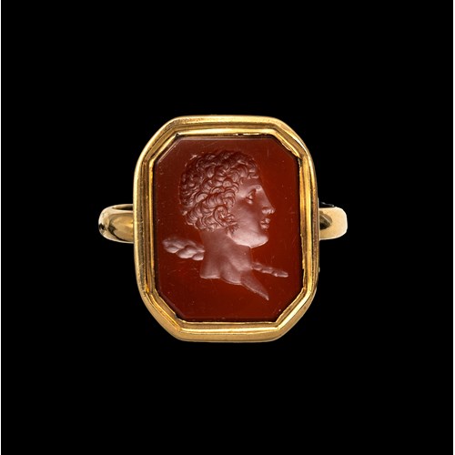 A 19th century gold ring set with a neoclassical carnelian intaglio. Bust of young Hercules.